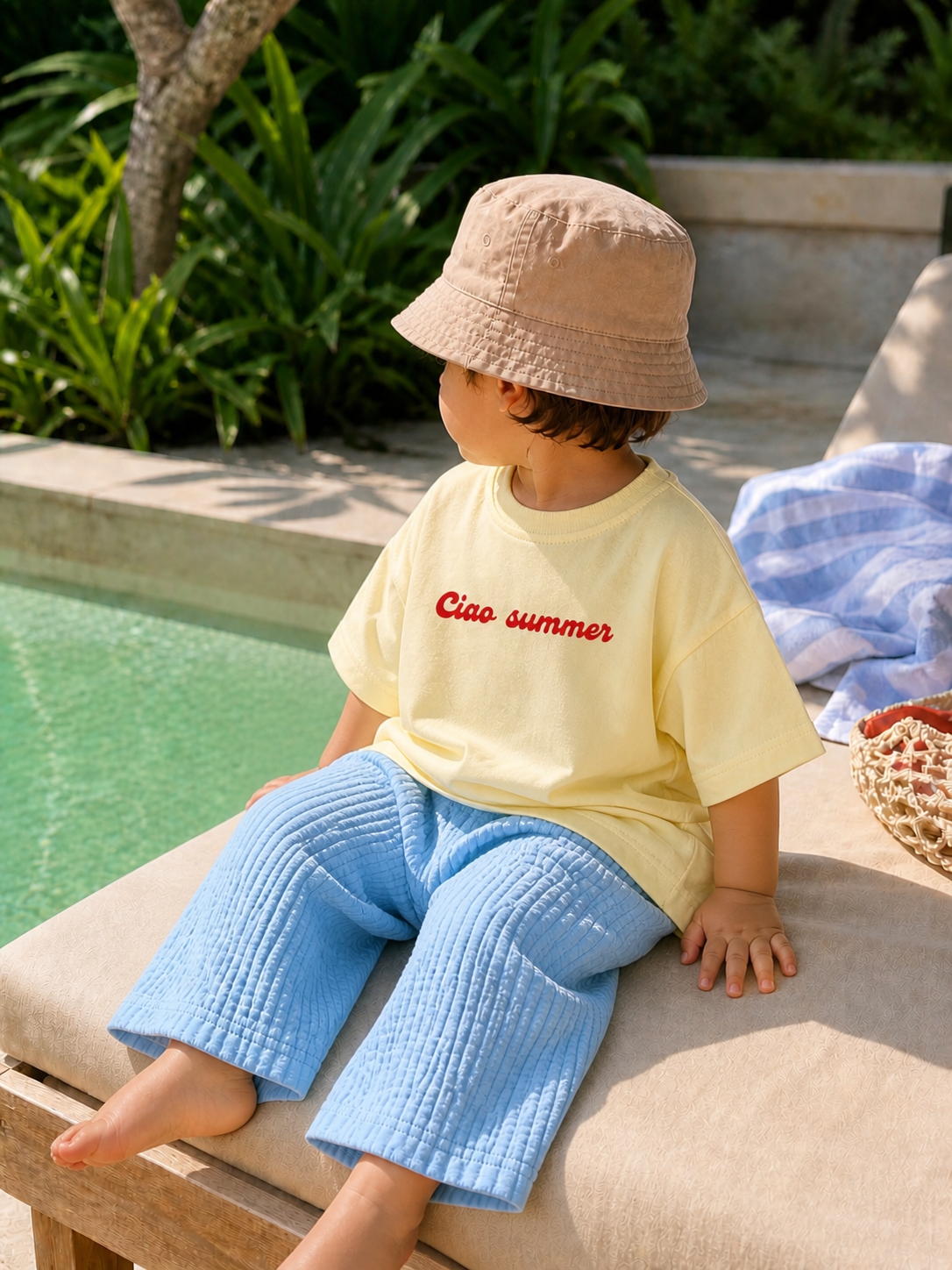 Toddler relaxing outdoors wearing Boo and Coo Ciao Summer oversized tee