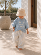Toddler wearing Boo and Coo coastal stripe linen pants in a relaxed summer outfit